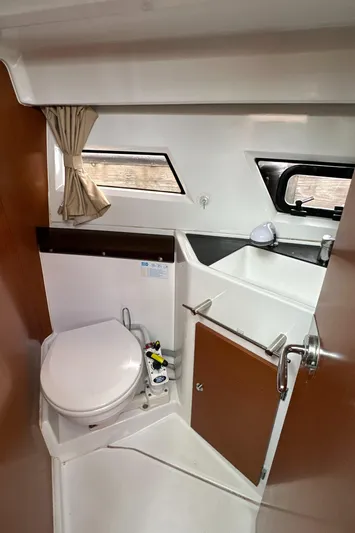 Something Special Yacht Photos Pics 2016 Jeanneau Merry Fisher 855 boat bathroom with toilet, sink, and window.