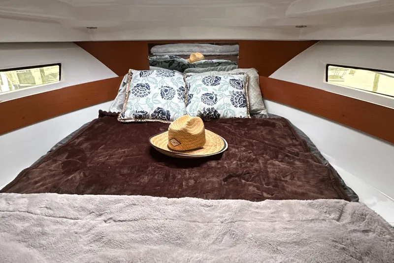 Something Special Yacht Photos Pics Cozy cabin interior of 2016 Jeanneau Merry Fisher 855 with plush bedding and decorative hat.