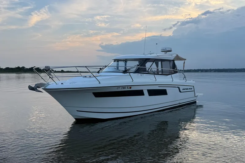 Something Special Yacht Photos Pics 2016 Jeanneau Merry Fisher 855 boat on calm water at sunset.