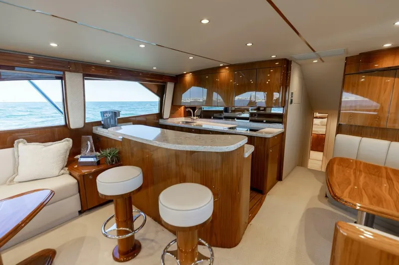 Galati Yacht Sales Trade Yacht Photos Pics Luxurious interior of 2020 Viking 62 Convertible yacht with modern kitchen and seating area.
