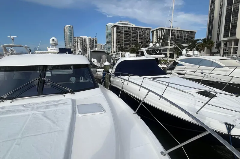  Yacht Photos Pics 2015 Riviera 5000 Sport Yacht docked in a marina with city skyline backdrop.