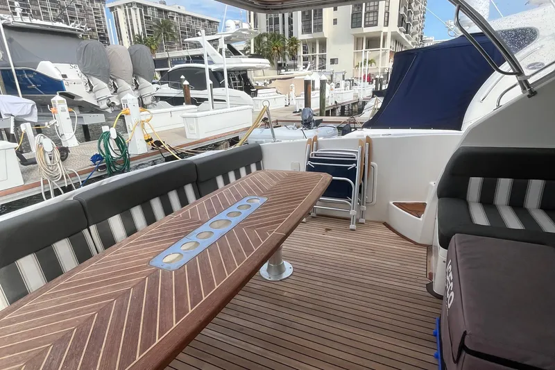  Yacht Photos Pics 2015 Riviera 5000 Sport Yacht interior with elegant wood table and striped seating.