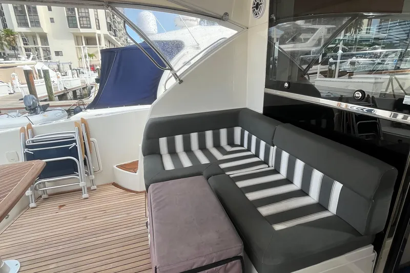  Yacht Photos Pics 2015 Riviera 5000 Sport Yacht interior with striped seating and wooden deck.