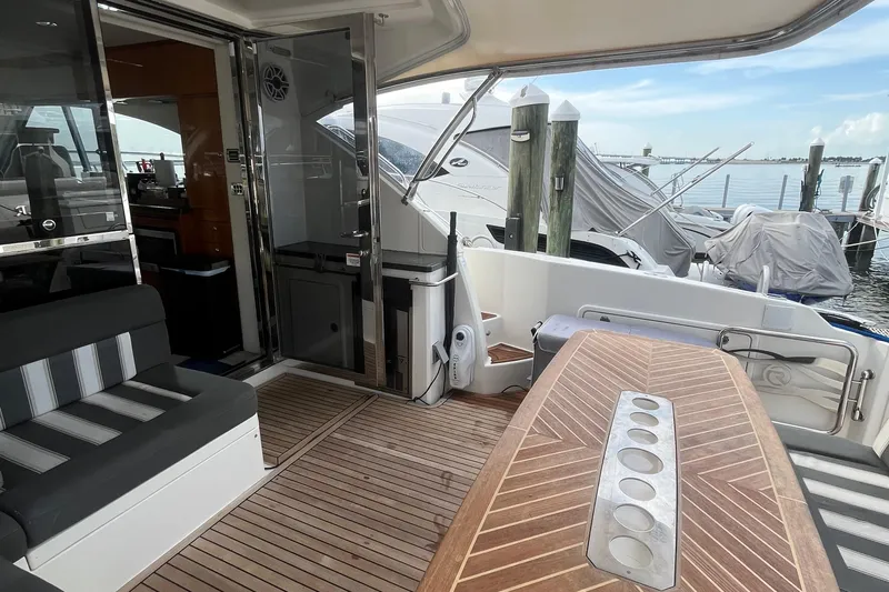 Yacht Photos Pics 2015 Riviera 5000 Sport Yacht interior with wooden deck and seating area.