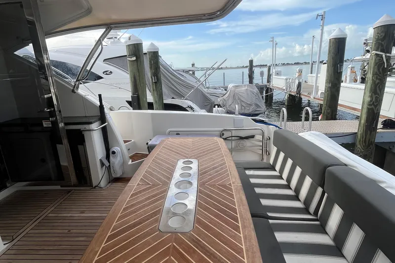  Yacht Photos Pics 2015 Riviera 5000 Sport Yacht with elegant deck seating and wooden table at marina.