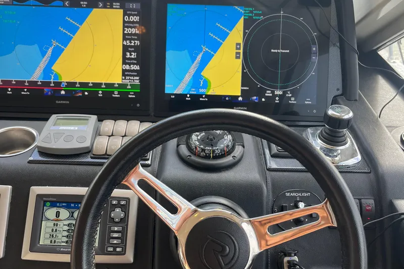 Yacht Photos Pics Cockpit of 2015 Riviera 5000 Sport Yacht with navigation screens and steering wheel.