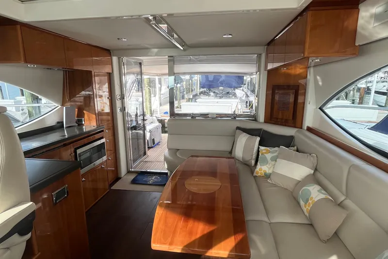  Yacht Photos Pics Luxurious interior of 2015 Riviera 5000 Sport Yacht with elegant wood finishes and plush seating.