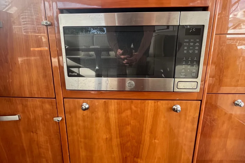  Yacht Photos Pics Built-in microwave in 2015 Riviera 5000 Sport Yacht's wooden cabinetry.