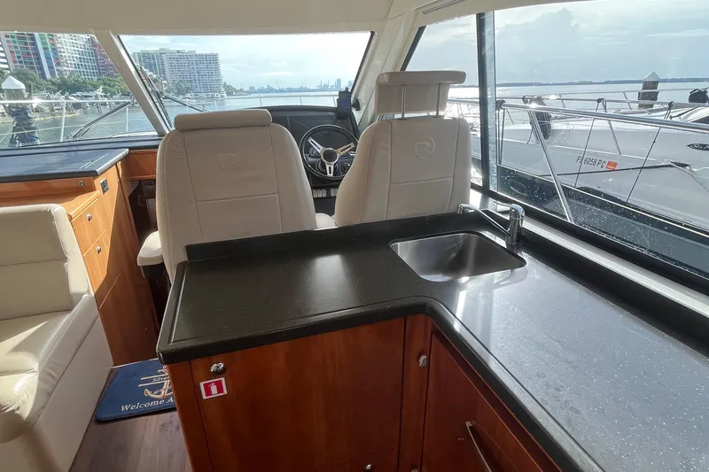  Yacht Photos Pics Interior of 2015 Riviera 5000 Sport Yacht with helm, sink, and luxurious seating.