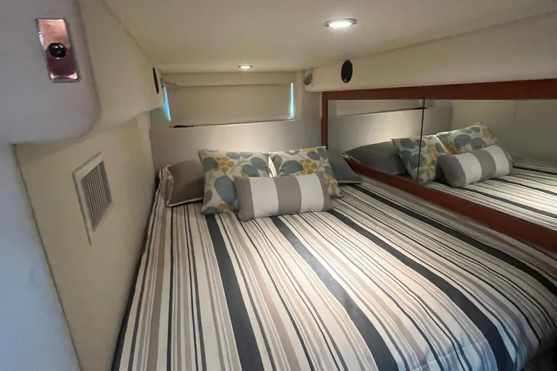  Yacht Photos Pics Interior cabin of 2015 Riviera 5000 Sport Yacht with striped bedding and decorative pillows.