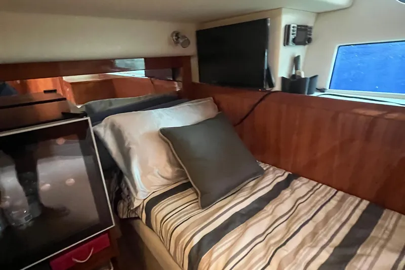 Yacht Photos Pics Cozy cabin interior of 2015 Riviera 5000 Sport Yacht with striped bedding and wooden accents.