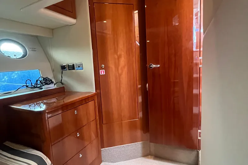  Yacht Photos Pics Interior of 2015 Riviera 5000 Sport Yacht with wooden cabinetry and porthole window.
