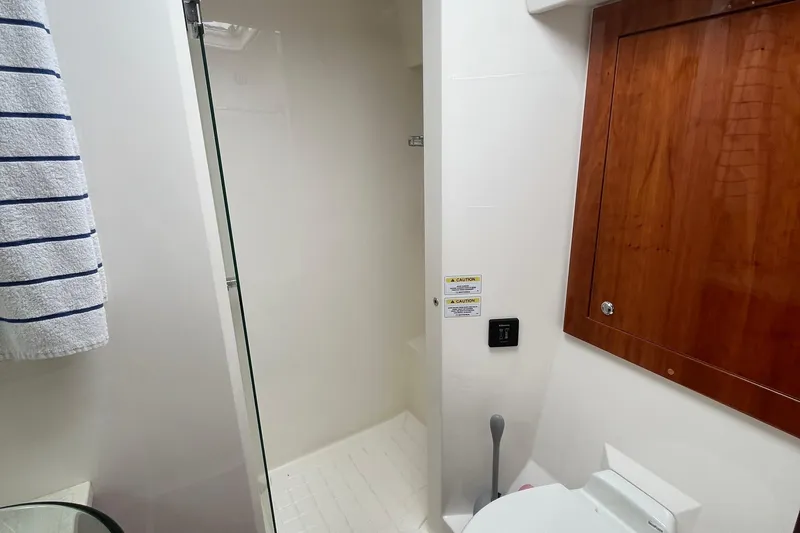  Yacht Photos Pics Bathroom interior of 2015 Riviera 5000 Sport Yacht with shower and wooden cabinet.