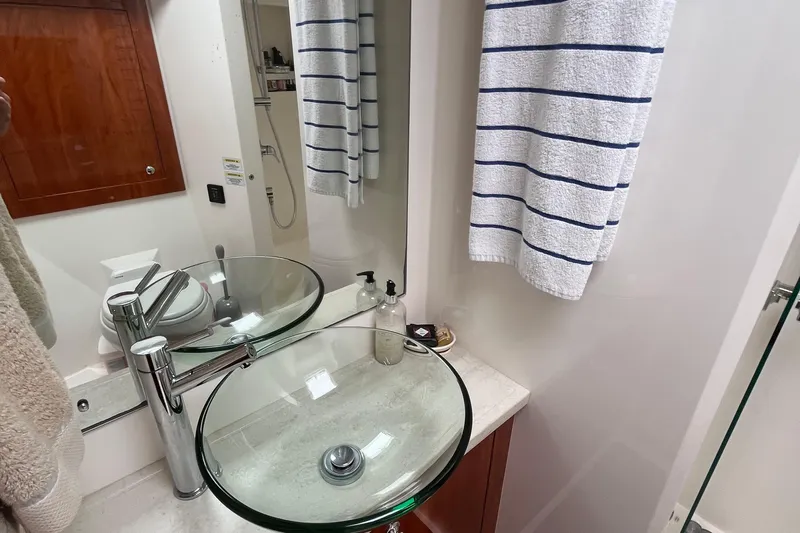  Yacht Photos Pics Luxurious bathroom in 2015 Riviera 5000 Sport Yacht with glass sink and striped towel.