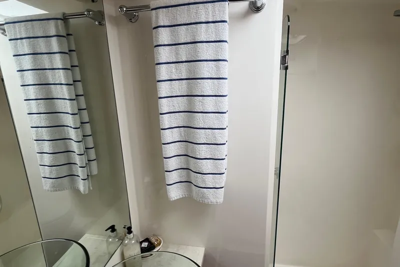  Yacht Photos Pics Bathroom interior of 2015 Riviera 5000 Sport Yacht with striped towel and glass shower.