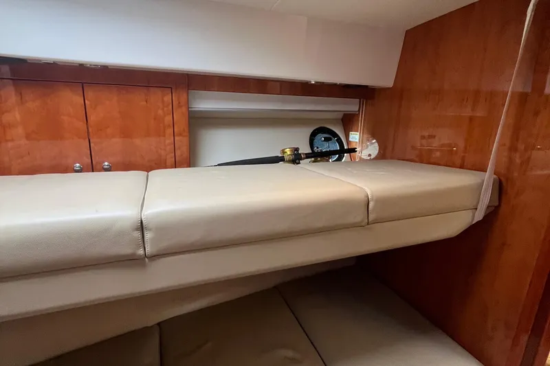  Yacht Photos Pics Interior cabin of 2015 Riviera 5000 Sport Yacht with beige seating and wooden cabinetry.