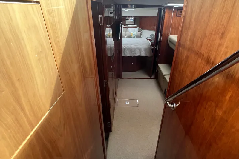  Yacht Photos Pics 2015 Riviera 5000 Sport Yacht interior with wood paneling and cozy bedroom.