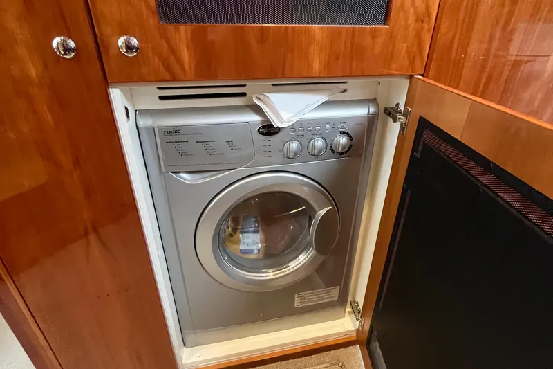  Yacht Photos Pics Compact washing machine in a 2015 Riviera 5000 Sport Yacht's wooden cabinet.