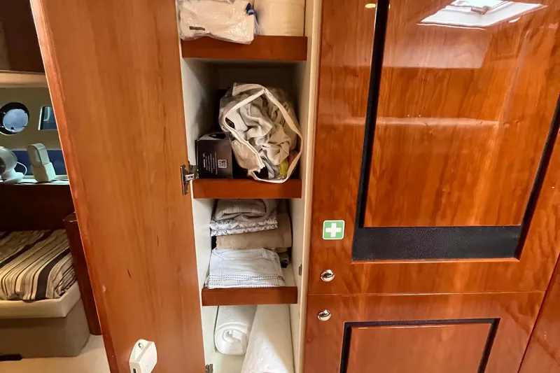  Yacht Photos Pics Interior of 2015 Riviera 5000 Sport Yacht showing wooden cabinet with shelves and stored items.