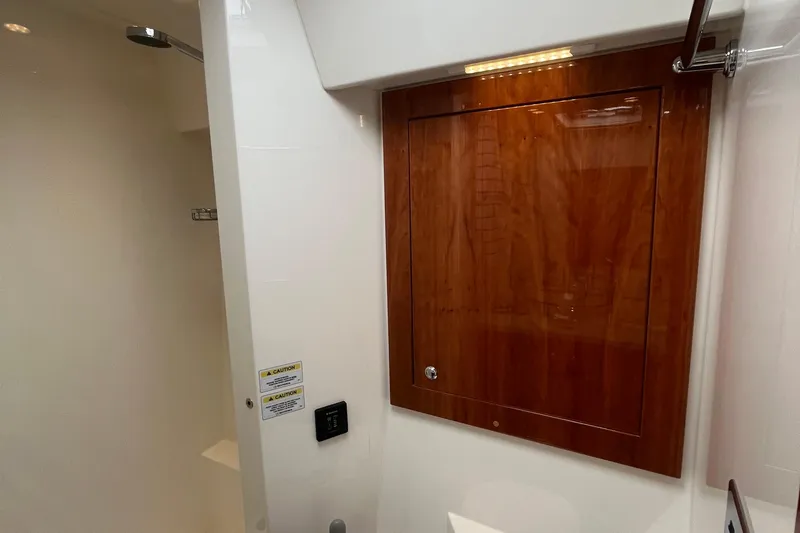  Yacht Photos Pics Interior of 2015 Riviera 5000 Sport Yacht, featuring wooden cabinetry and modern shower area.