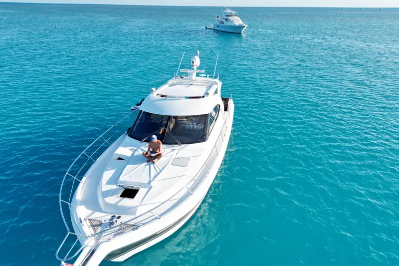  Yacht Photos Pics 2015 Riviera 5000 Sport Yacht cruising on clear blue ocean waters.