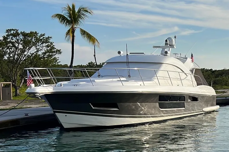  Yacht Photos Pics 2015 Riviera 5000 Sport Yacht docked near palm trees, reflecting on calm water.