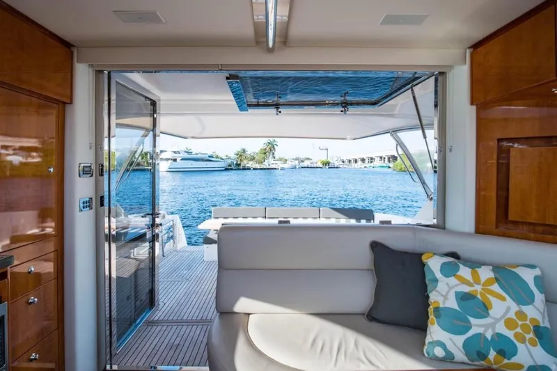  Yacht Photos Pics Interior view of 2015 Riviera 5000 Sport Yacht with open deck and waterfront scenery.