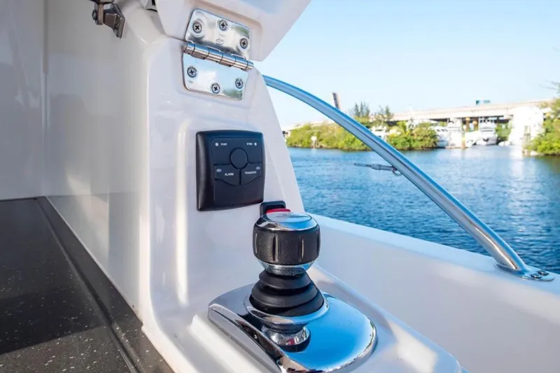  Yacht Photos Pics Control panel and joystick on 2015 Riviera 5000 Sport Yacht, overlooking serene waterway.