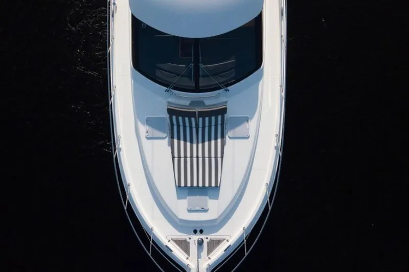  Yacht Photos Pics Aerial view of 2015 Riviera 5000 Sport Yacht with striped sunbed on deck.
