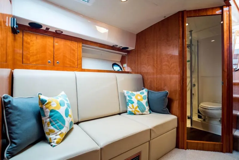  Yacht Photos Pics Interior of 2015 Riviera 5000 Sport Yacht with beige sofa and colorful cushions.