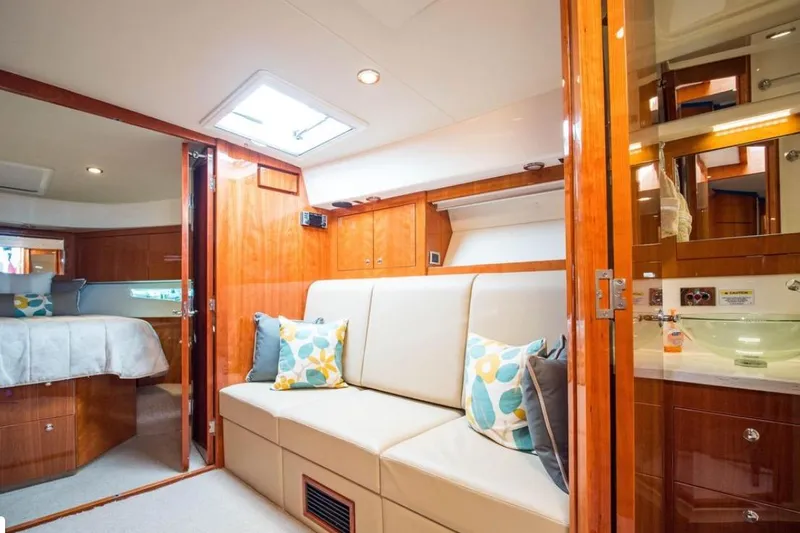  Yacht Photos Pics Luxurious interior of 2015 Riviera 5000 Sport Yacht with cozy seating and elegant wood finishes.