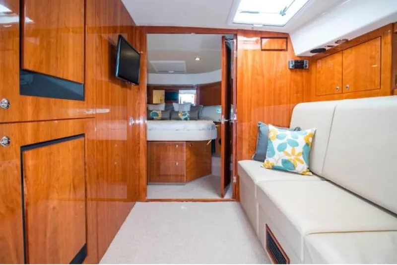  Yacht Photos Pics Interior of 2015 Riviera 5000 Sport Yacht with wood paneling and cozy seating area.