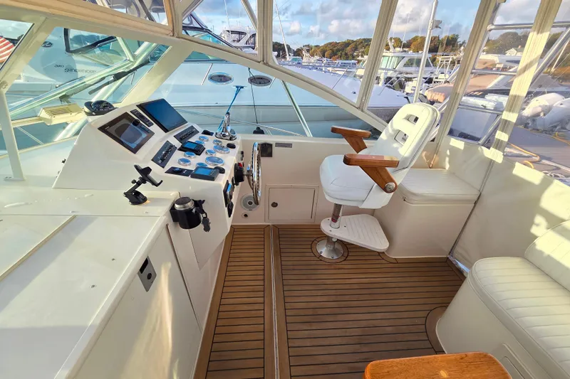 Aggievation Yacht Photos Pics 2007 Carolina Classic 28 Express boat cockpit with helm, controls, and seating on teak flooring.