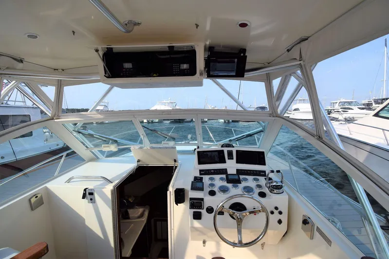 Aggievation Yacht Photos Pics 2007 Carolina Classic 28 Express boat cockpit with steering wheel and control panel, docked at marina.