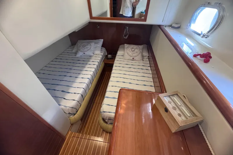  Yacht Photos Pics Twin cabin in 2010 Ferretti Yachts 620, featuring striped bedding and wooden accents.