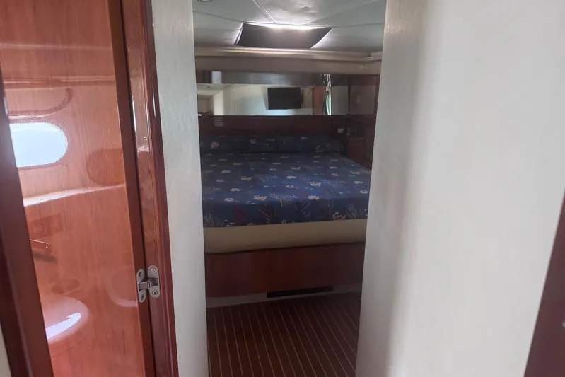  Yacht Photos Pics Interior cabin of 2010 Ferretti Yachts 620 with wooden finishes and cozy bed.