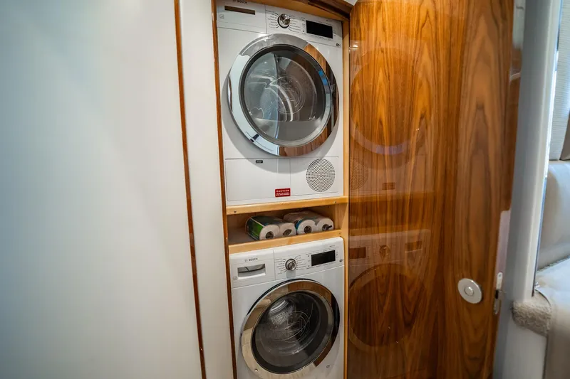 Lori A Yacht Photos Pics Laundry area with stacked washer and dryer in 2021 Viking 54 Convertible yacht.