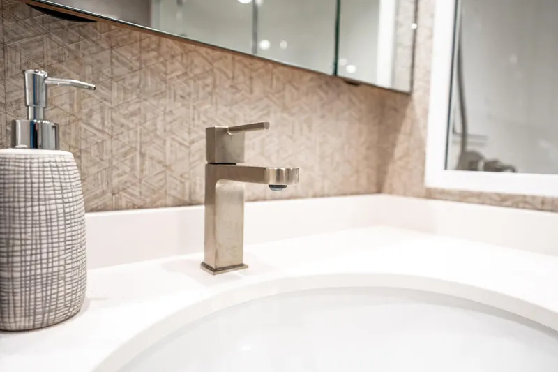 Lori A Yacht Photos Pics Modern bathroom sink with sleek faucet and textured soap dispenser on Viking 54 Convertible yacht.