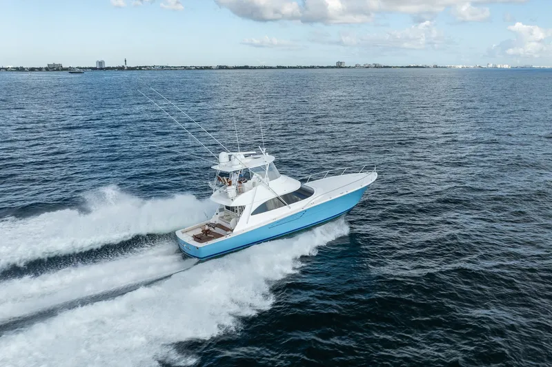 Lori A Yacht Photos Pics 2021 Viking 54 Convertible yacht cruising on open water under a partly cloudy sky.