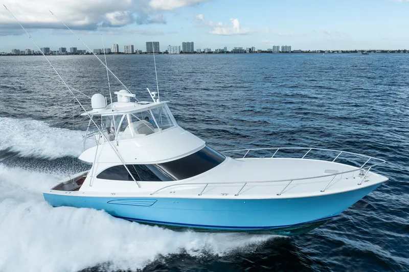 Lori A Yacht Photos Pics 2021 Viking 54 Convertible yacht cruising on open water, city skyline in background.