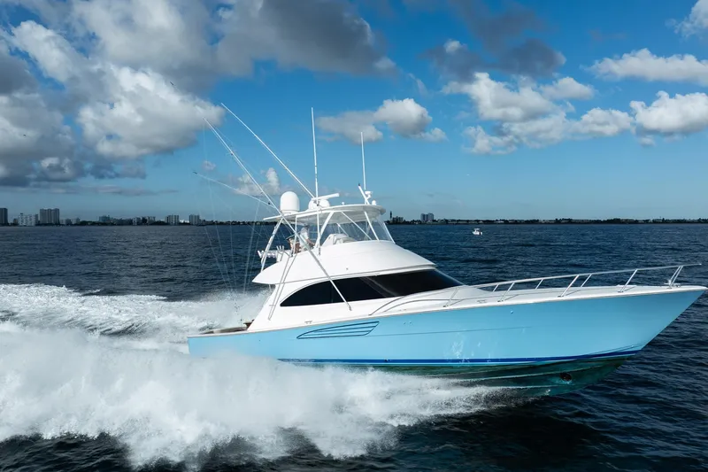 Lori A Yacht Photos Pics 2021 Viking 54 Convertible yacht cruising on open water under a blue sky.