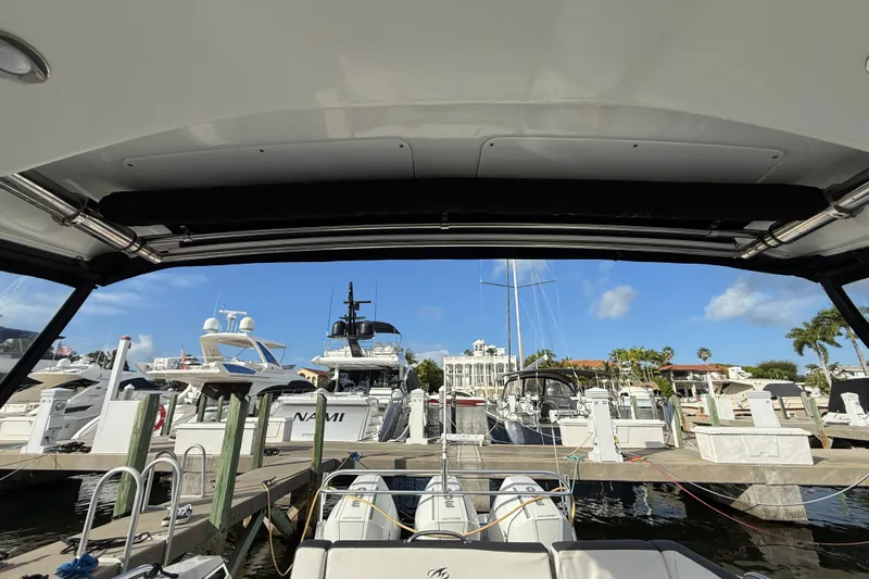  Yacht Photos Pics 2022 Monterey 385SS Super Sport at marina, surrounded by luxury yachts and clear blue sky.