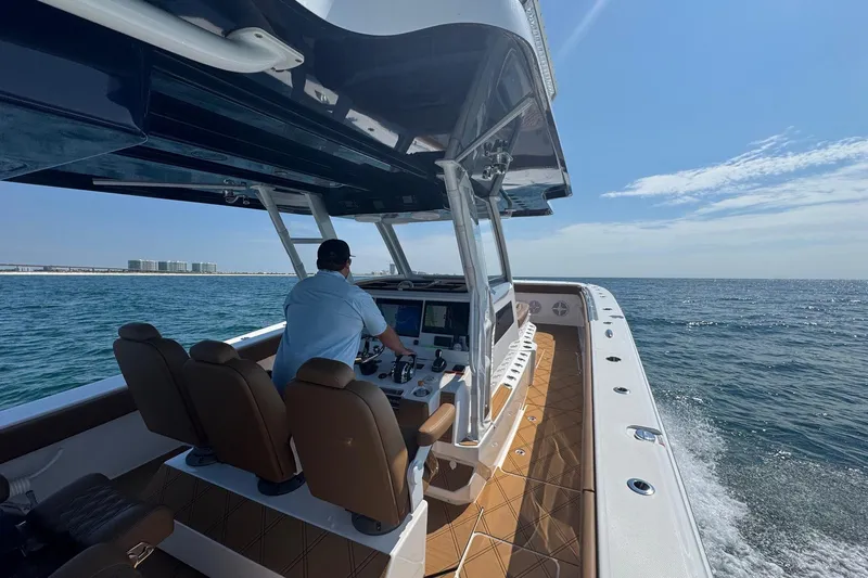  Yacht Photos Pics 2024 Invincible 46 Catamaran cruising on open water, featuring modern helm and seating.