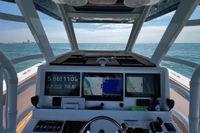  Yacht Photos Pics 2024 Invincible 46 Catamaran helm with navigation screens, steering wheel, and ocean view.