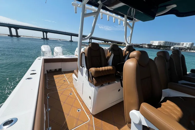  Yacht Photos Pics 2024 Invincible 46 Catamaran with luxurious seating, cruising near a scenic bridge.