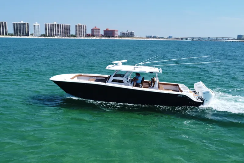  Yacht Photos Pics 2024 Invincible 46 Catamaran cruising on ocean near city skyline.