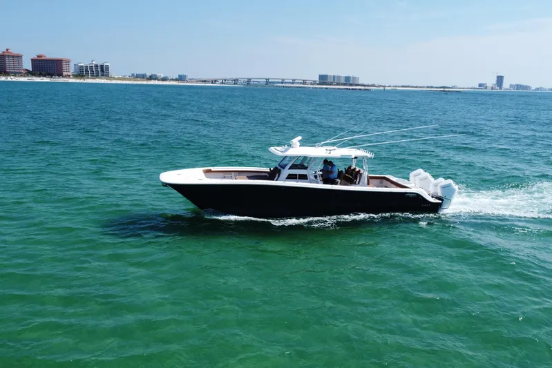  Yacht Photos Pics 2024 Invincible 46 Catamaran cruising on clear blue ocean waters.