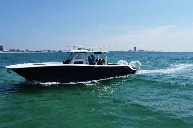  Yacht Photos Pics 2024 Invincible 46 Catamaran cruising on open water under clear skies.