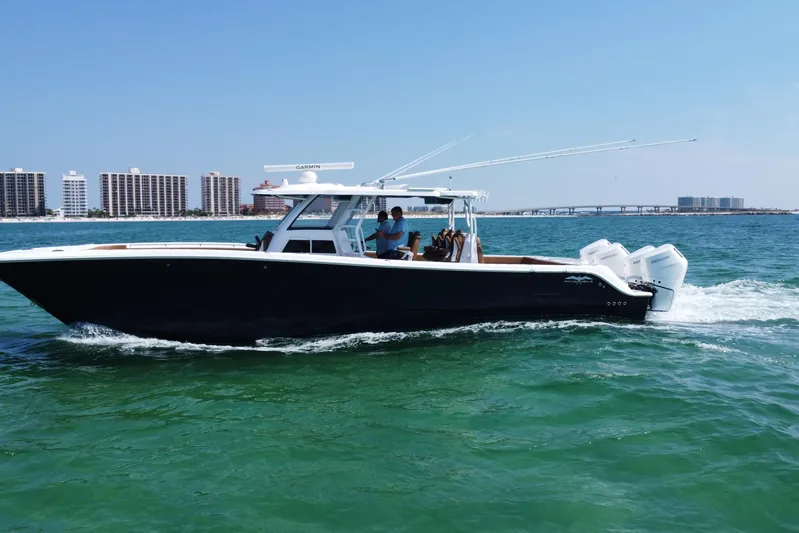  Yacht Photos Pics 2024 Invincible 46 Catamaran cruising on ocean near city skyline.