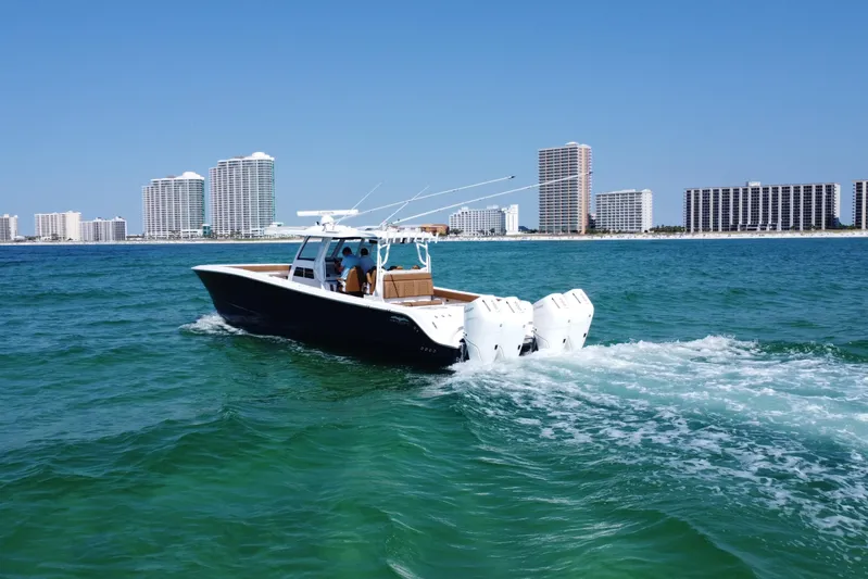  Yacht Photos Pics 2024 Invincible 46 Catamaran cruising on ocean with city skyline in background.